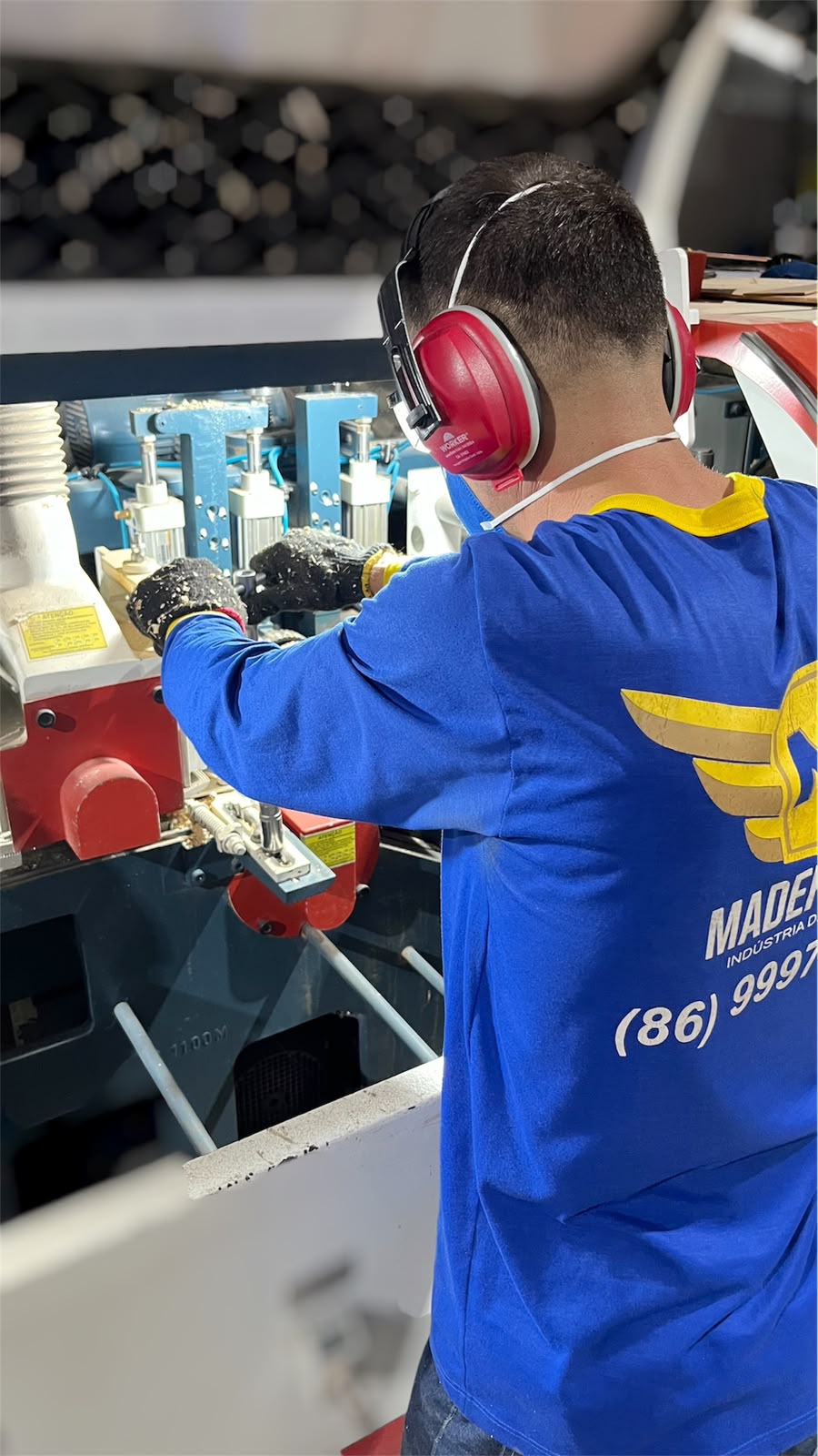 Funcionário da Madeferro operando máquina de produção com equipamento de proteção